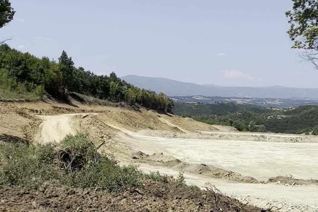 Pogled preko raščišćenog platoa ka dolini. Šumska ivica je odsečena, teren poravnat.